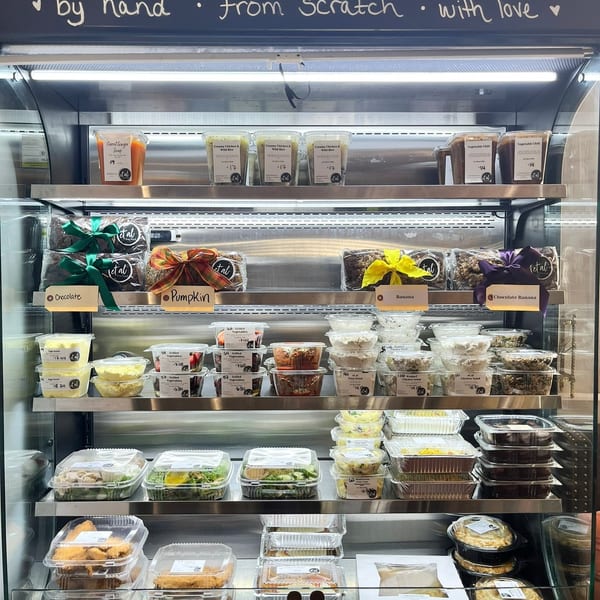 A refrigerated display case filled with various pre-packaged meals, salads, and desserts.